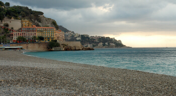 Nice's rocky beach and blue Mediterranean waters, with Castle Hill in the background. Credit: Julie Kalan