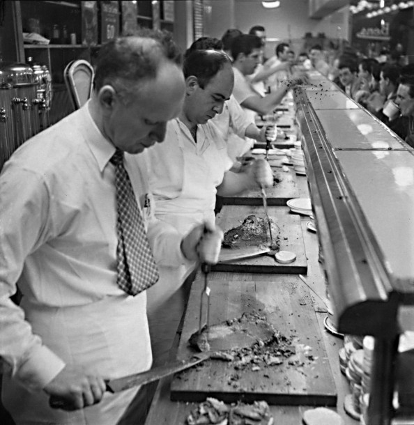 Al Kravitz slicing smoked meat behind the counter in 1952
