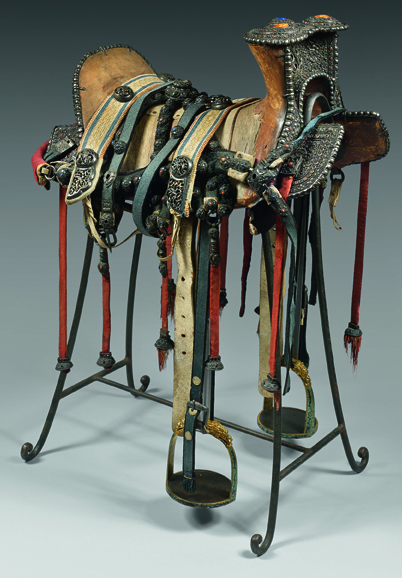 A Sino-Mongolian saddle inlaid with semi-precious stones including lapis-lazuli, coral, and amber.