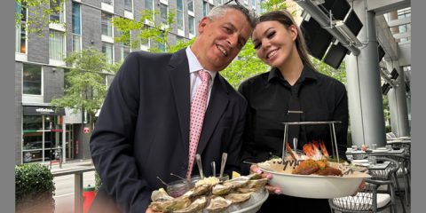 David Zaltzman and server Megan present the magnificent seafood tower at Moishes Steakhouse