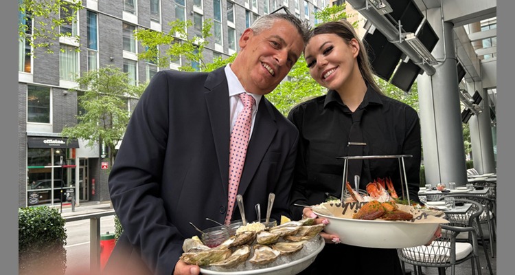 David Zaltzman and server Megan present the magnificent seafood tower at Moishes Steakhouse